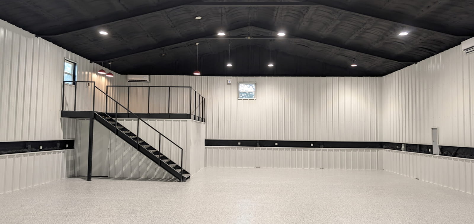 Empty white room with black ceiling, loft, and staircase.
