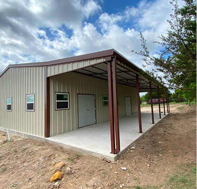A beige metal building with a large porch and brown trim.